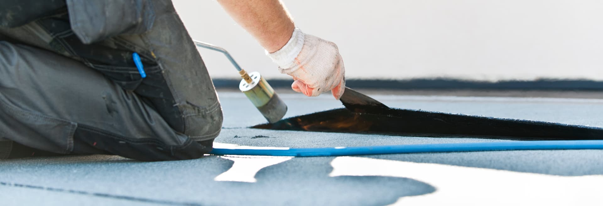 Modified bitumen being torch-applied on a flat roof